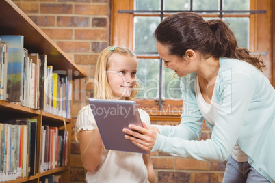 Teacher helping a student use a tablet