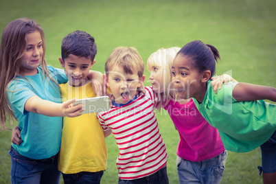 Smiling classmates posing funny and taking selfies