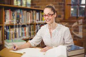 Blonde teacher correcting in the library