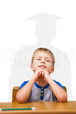 Composite image of smiling pupil sitting at his desk