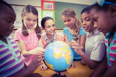 Teacher and pupils looking at globe