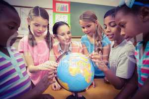 Teacher and pupils looking at globe