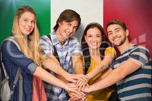 Composite image of college students placing hands together