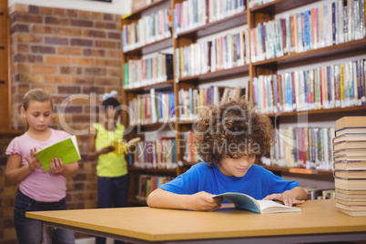 Happy pupil reading a library book