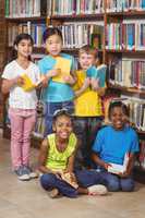 Smiling pupils with books in the library