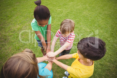 Diverse classmates putting hands together