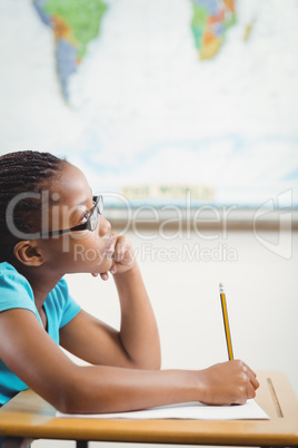 Focused pupil working at her desk in a classroom