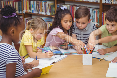 Pupils working together at desk in library