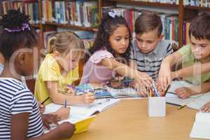 Pupils working together at desk in library