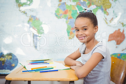 Smiling student with a book on the desk