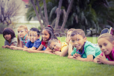 Cute pupils lying on the grass outside