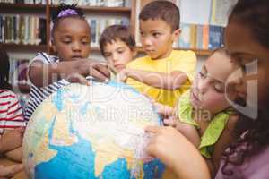 Pupils looking at globe in library