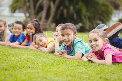 Cute pupils lying on the grass outside