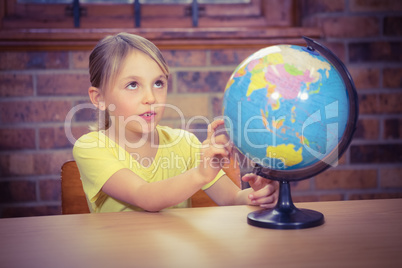 Students pointing at a globe