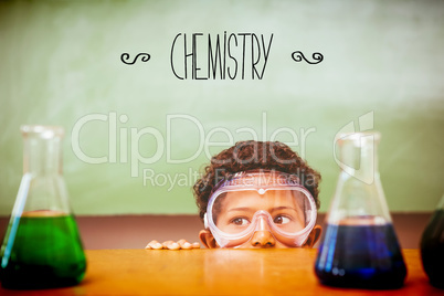 Chemistry against boy looking at conical flasks in classroom