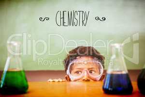 Chemistry against boy looking at conical flasks in classroom