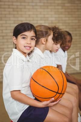 Student holding basketball with fellow players