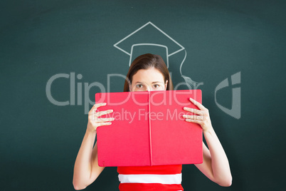 Composite image of student holding book over face