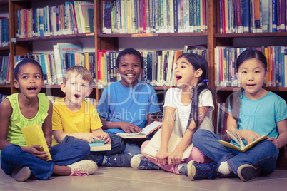 Pupils sitting on the ground and reading books in the library