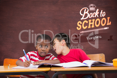 Composite image of cute pupils writing at desk in classroom Composite image of cute pupils writing at desk in classroom