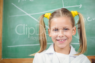 Cute pupil with lab coat in front of chalkboard