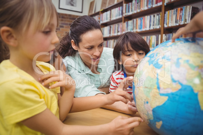 Pupils and teacher looking at globe in library Pupils and teacher looking at globe in library