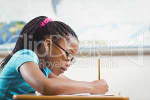Focused pupil working at her desk in a classroom