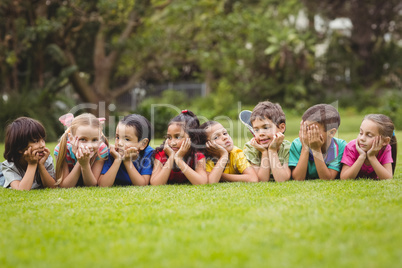 Cute pupils lying on the grass outside