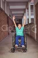Smiling student in a wheelchair with arms raised