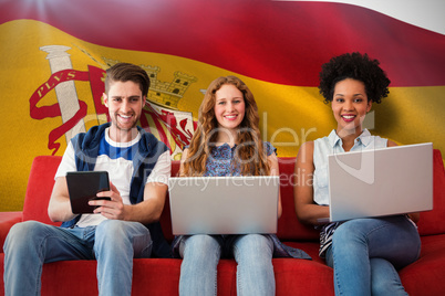 Composite image of young adults using electronic devices on couc