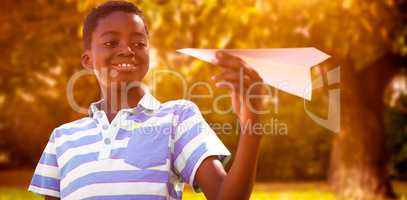 Composite image of cute little boy with paper airplane