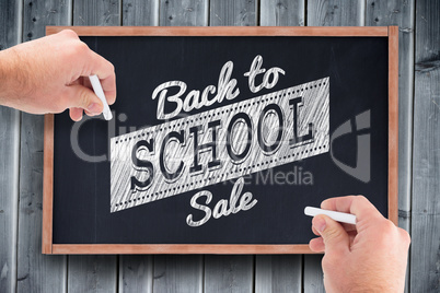 Composite image of business man writing with chalk