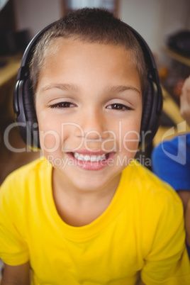 Cute pupil in computer class smiling at camera