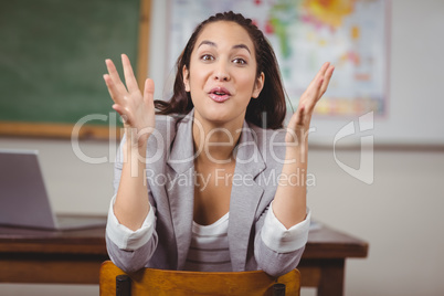 Pretty teacher sitting on chair and talking