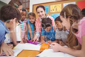 Teacher and pupils working at desk together