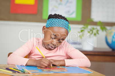 Focused pupil colouring a picture at her desk