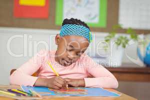 Focused pupil colouring a picture at her desk