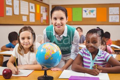 Teacher and pupils smiling at camera in classroom