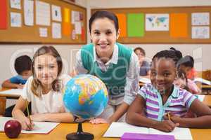 Teacher and pupils smiling at camera in classroom