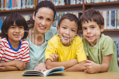 Pupils and teacher reading book in library