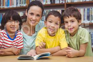 Pupils and teacher reading book in library