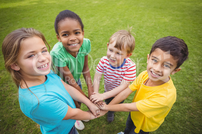 Smiling classmates putting hands together