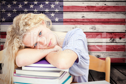 Composite image of tired teeenager sleeping in a library