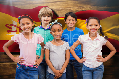 Composite image of cute pupils smiling at camera in classroom