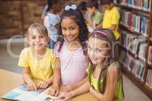 Pupils reading book together in library