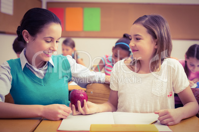 Pupil offering an apple to teacher