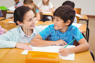 Teacher helping a little boy during class