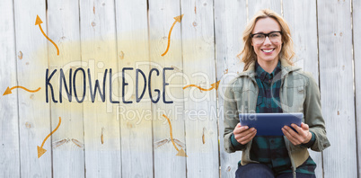Knowledge against smiling blonde in glasses using tablet pc