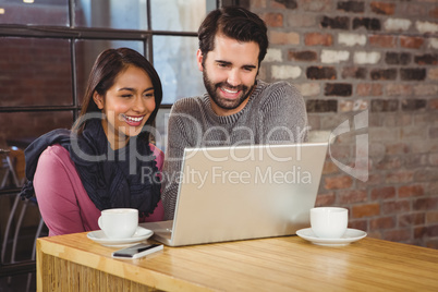 Young happy couple looking at a laptop