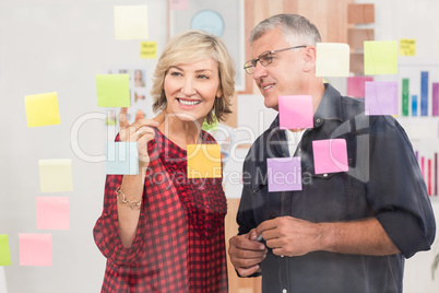 Business team pointing post its on the wall